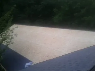 New OSB roof sheathing installed beside an existing shingle roof in Berlin